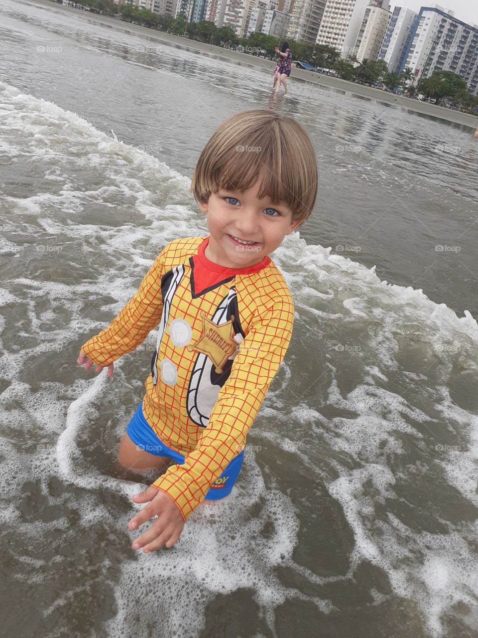 blond boy smiling on the beach of santos