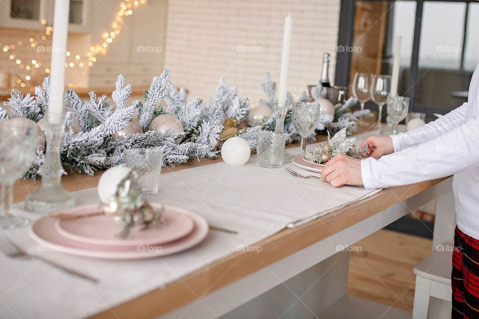 man sets a beautiful decorated winter table for a festive dinner.  Merry Christmas and Happy New Year.