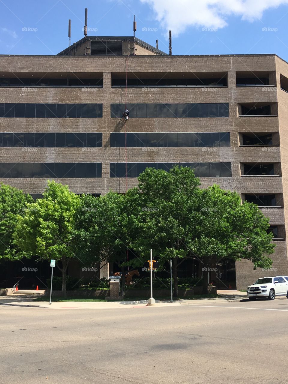 This is a photo of the craziest job on the planet, I saw him swinging from this building 