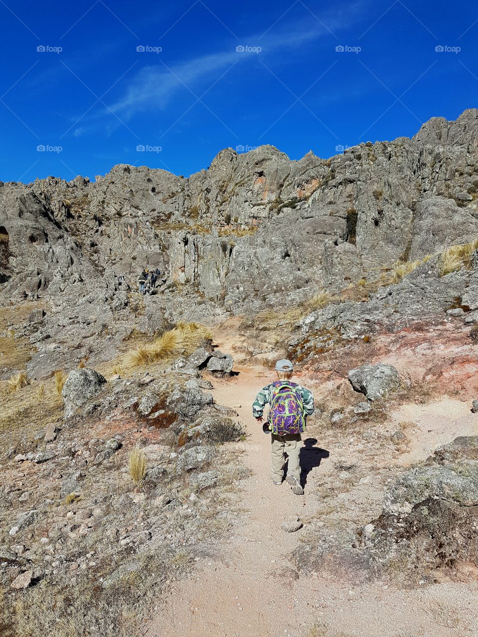 child hiking mountains trough path