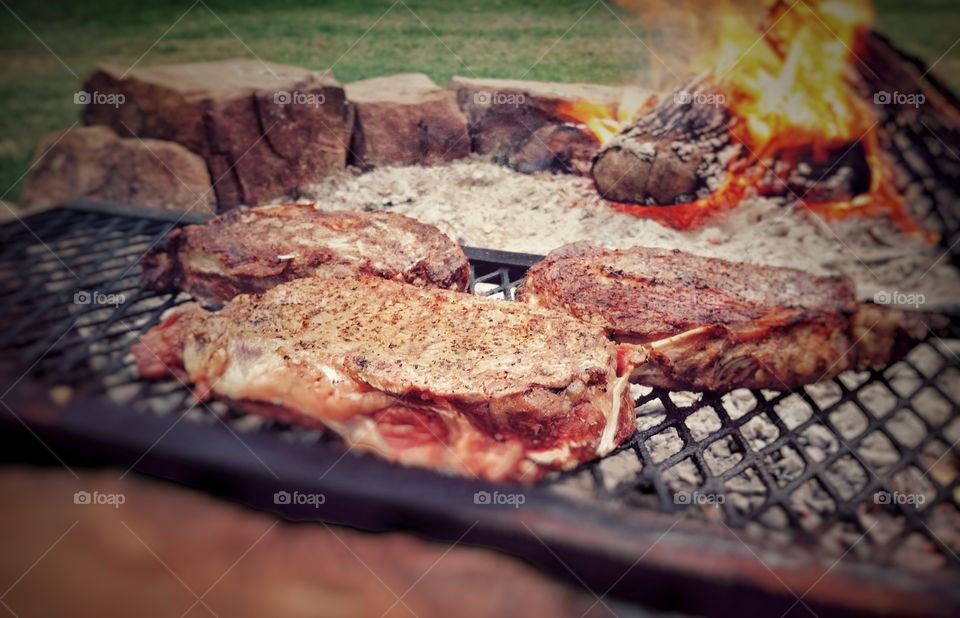 Ribeye steak on grill with fire