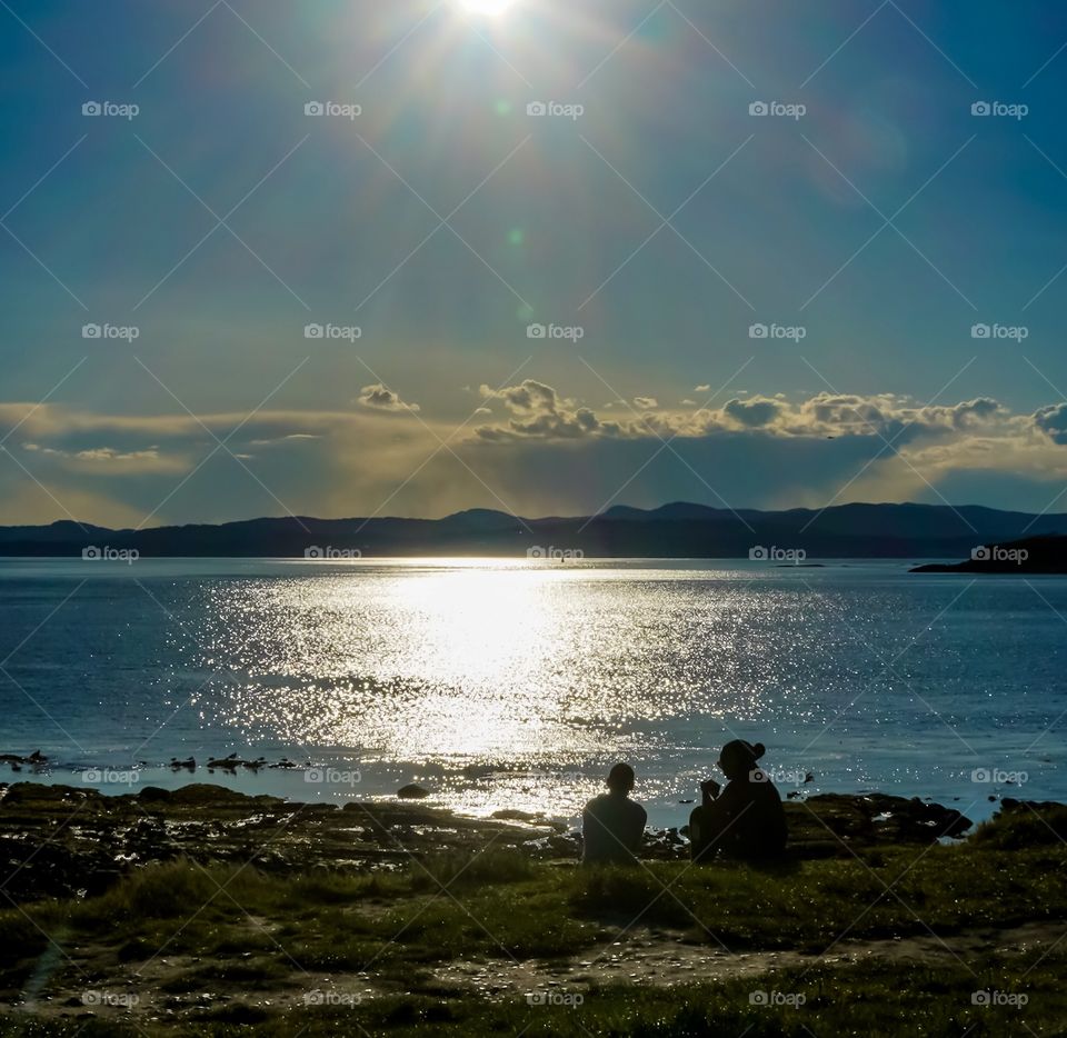 Sitting by the seaside in silhouette 