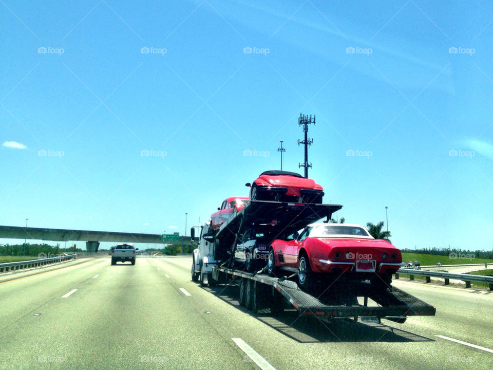 Classic cars on tow truck in highway