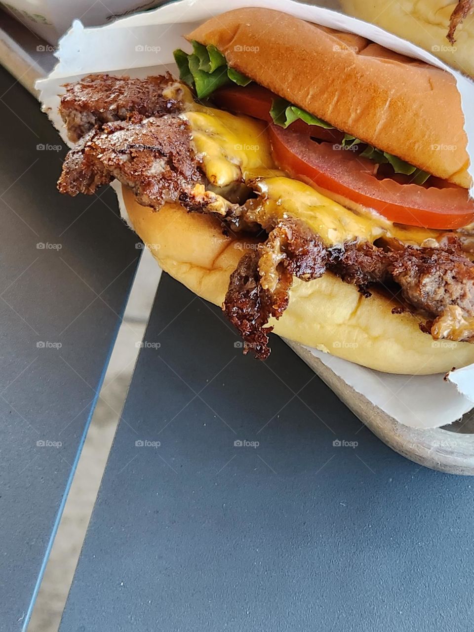 close up of restaurant cheeseburger with tomato