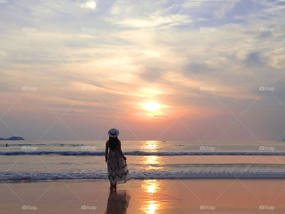 Young woman enjoying the golden hour over the sea 