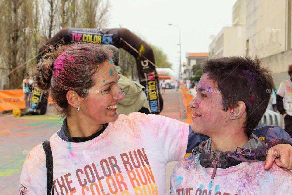 Mother and son covered in colorful paint, smiling happily at each other after finishing the Color Run in Porto, Portugal