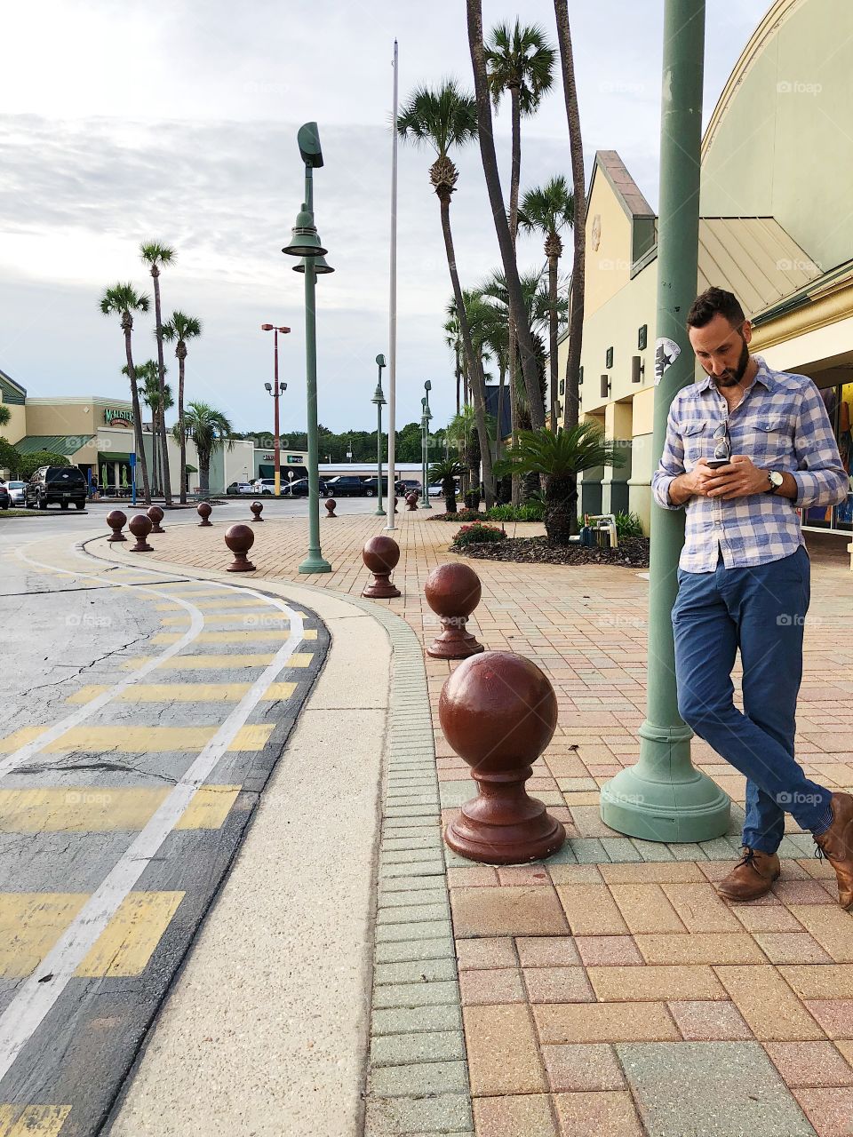 Man Waiting in City on Phone
