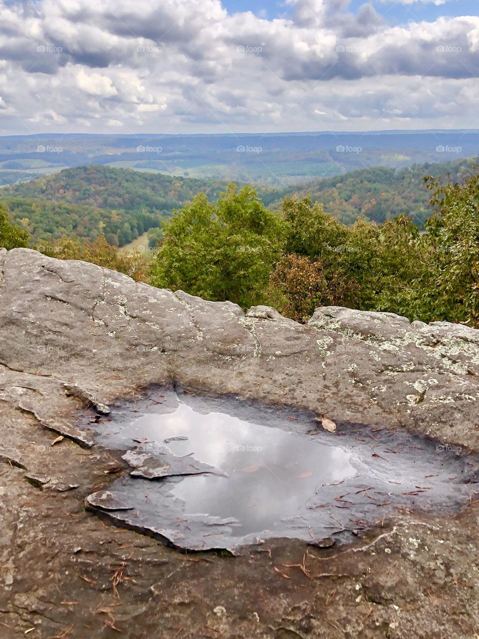 Looking out at the foothills and forests of the Appalachian mountain chain. The view from a cliff contrasts the distant sky with its closer reflection.