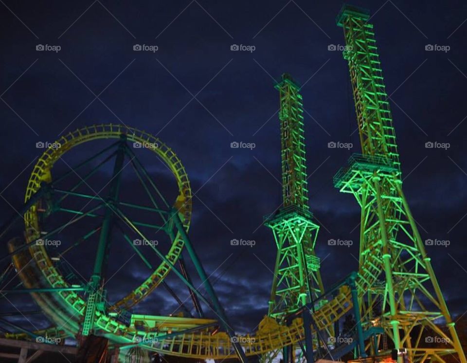 Roller coaster lit up green at night
