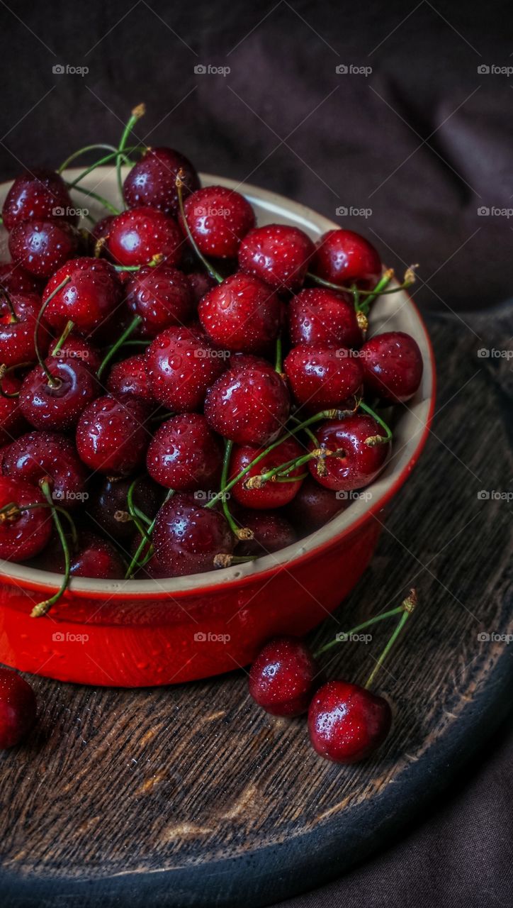 sweet cherries with red bowl with water drops