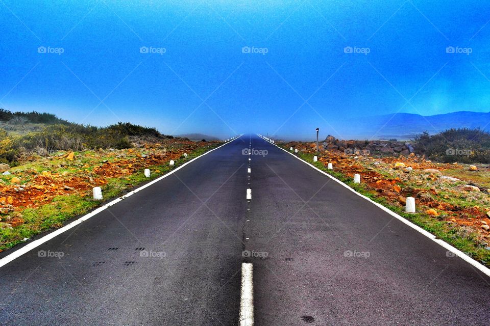 Empty road against blue sky