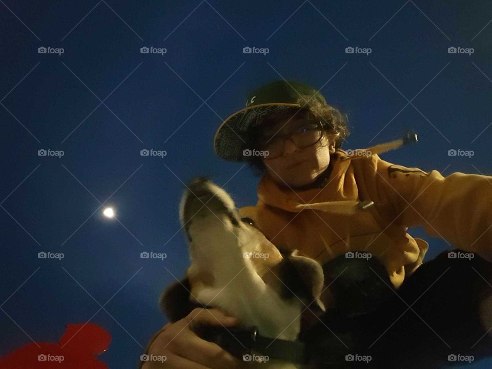 Person with dog and moon, in motion.