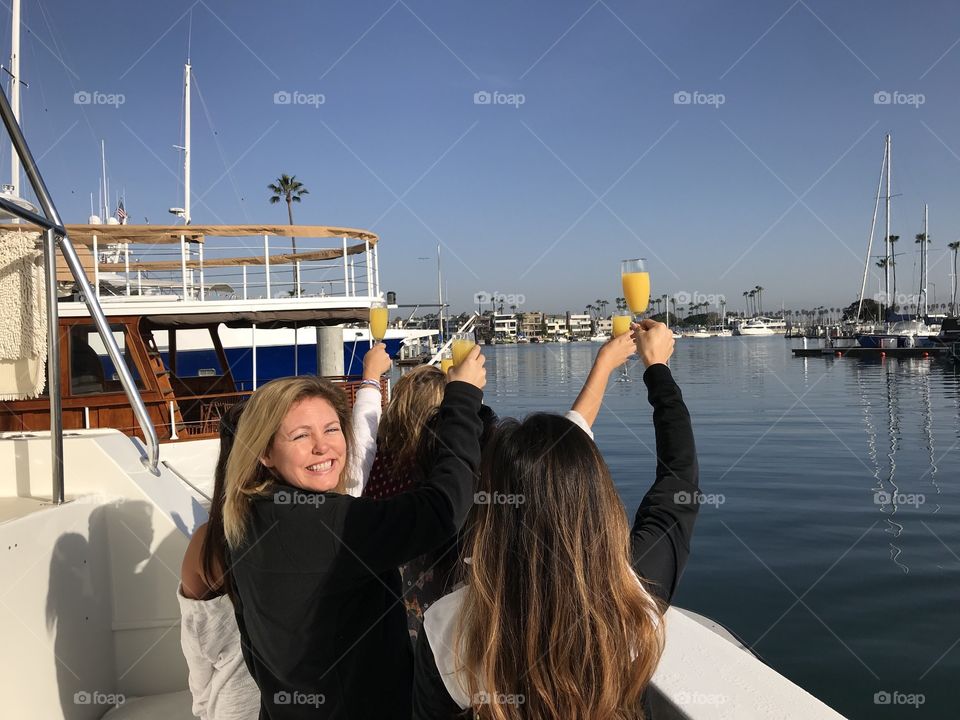 Women on yacht with champagne glasses. Boat