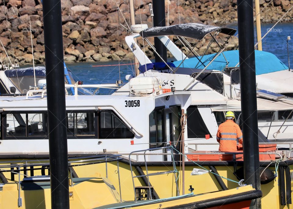 Boats and workers at the dock in ocean marina harbour 