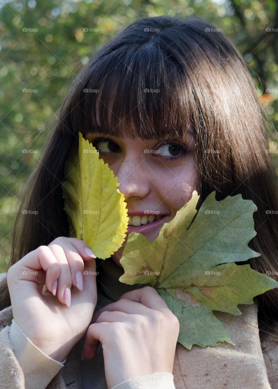 Portrait of Smiling Young Girl on Autumn Background