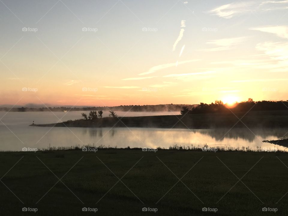 Sunrise over a foggy lake