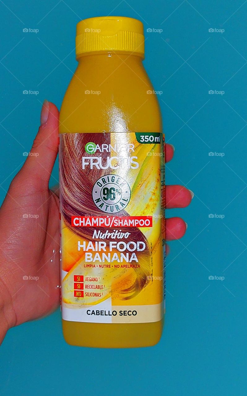 A yellow shampoo bottle in blue water.