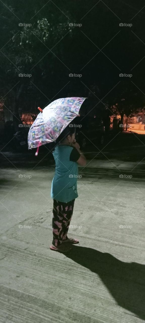 A beautiful little girl standing in rain, she holds umbrella ☔ she wants enjoy in rain ☔😻. This is years first rain. Nice, cool climate.
