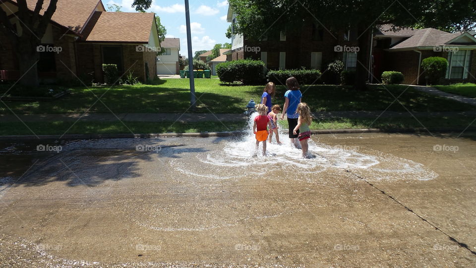 Girls. playing in the street fire hydrant