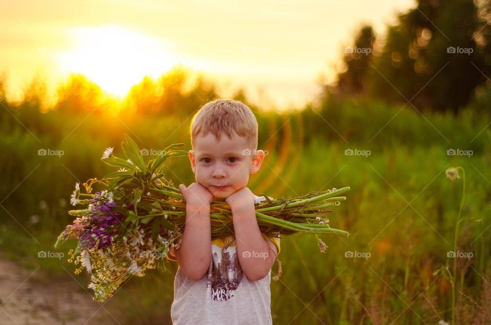 Boy with a big bouquet of flowers.