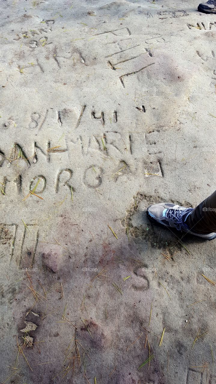 Previous generations left their mark on a stone trail ledge in the form of name graffiti.