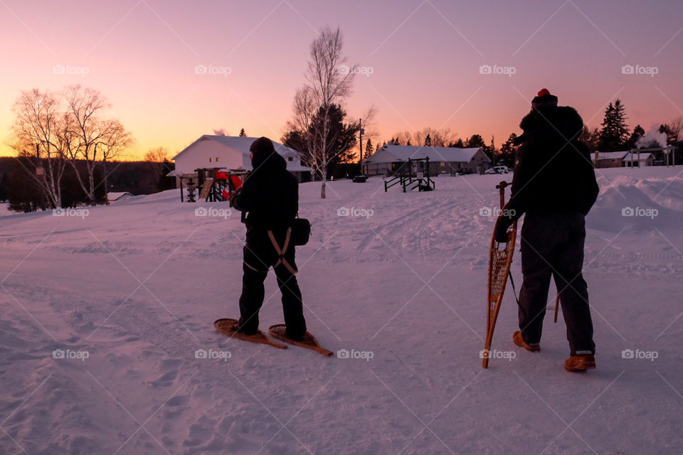 Snow shoeing in the winter at sunset