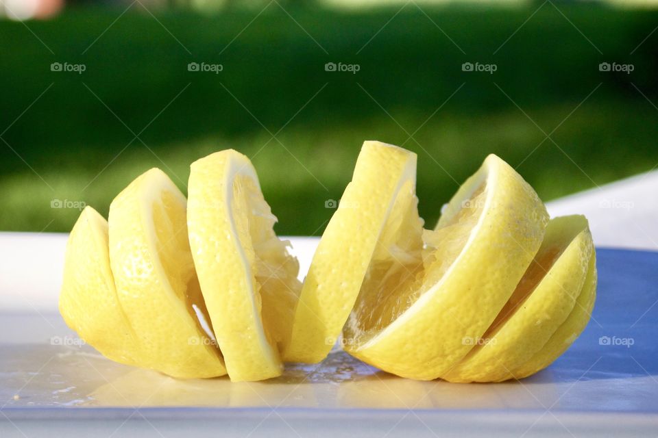 Fruits! - Spiral-cut lemon on a white plate outdoors in sunlight