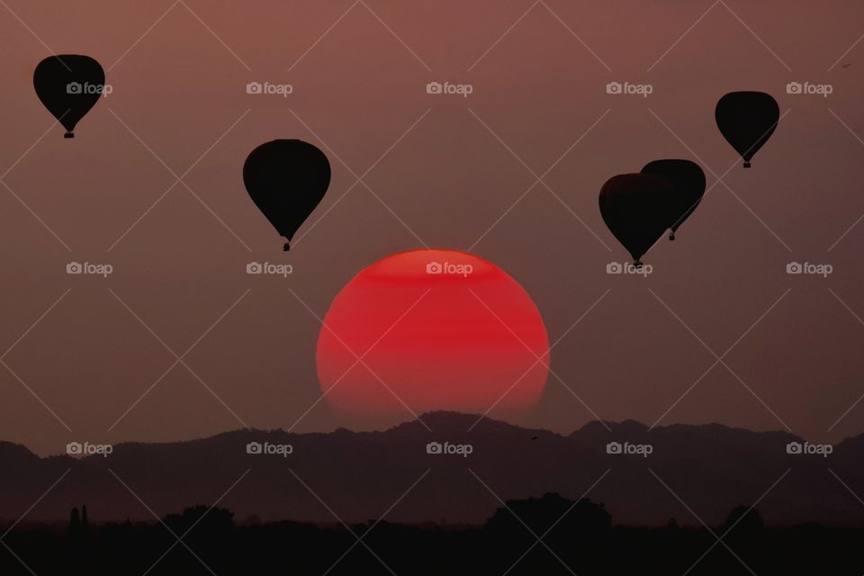 Silhouette balloon float over sunset background