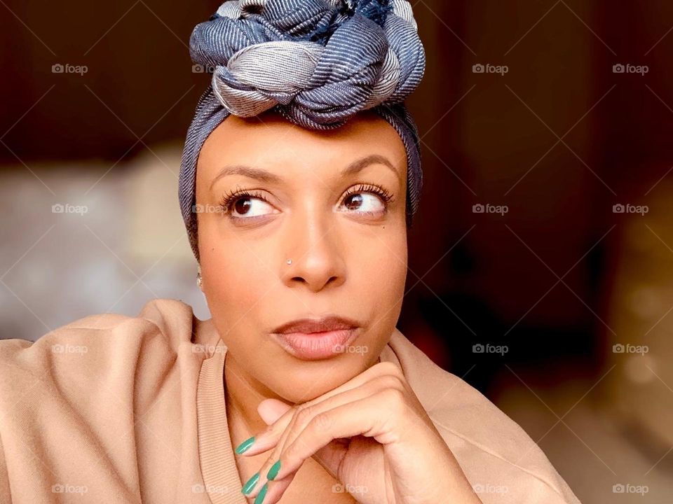 A self portrait of a woman wearing makeup and a head wrap.