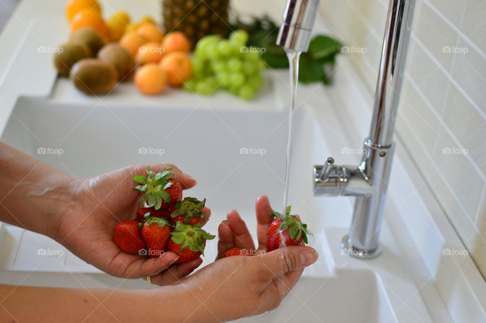 Cutting the strawberries to prepare a fruit salad 