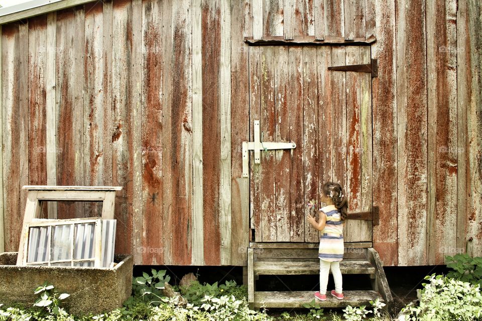 Little girl by the door of rustic barn