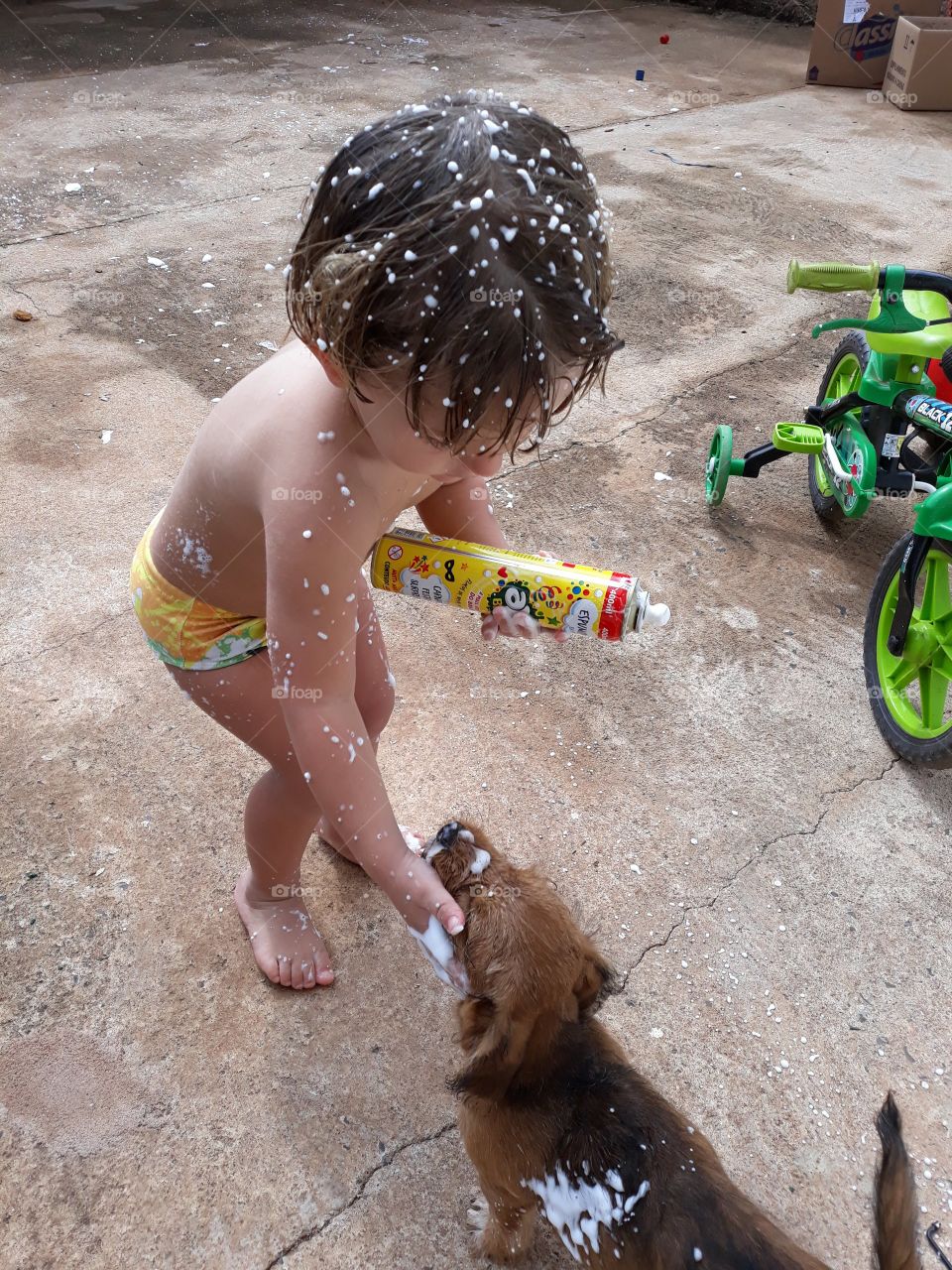 child playing with the dog with foam