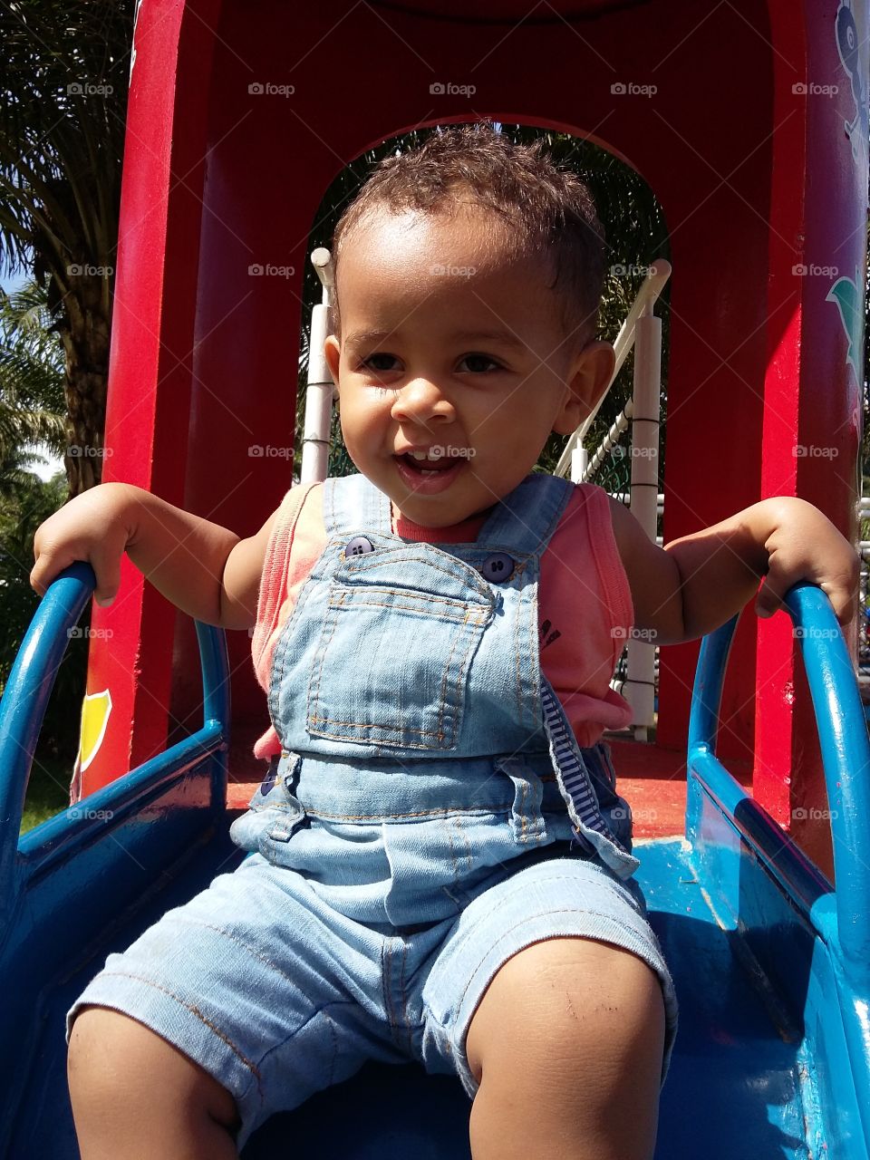 Little baby boy on slide in park