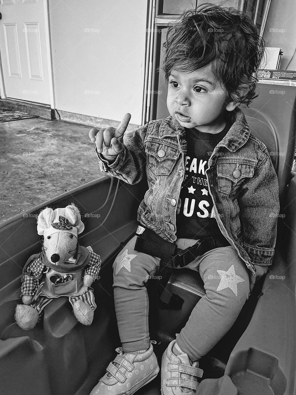 Little girl ready for a wagon ride, black and white portrait, riding in a wagon with Mommy