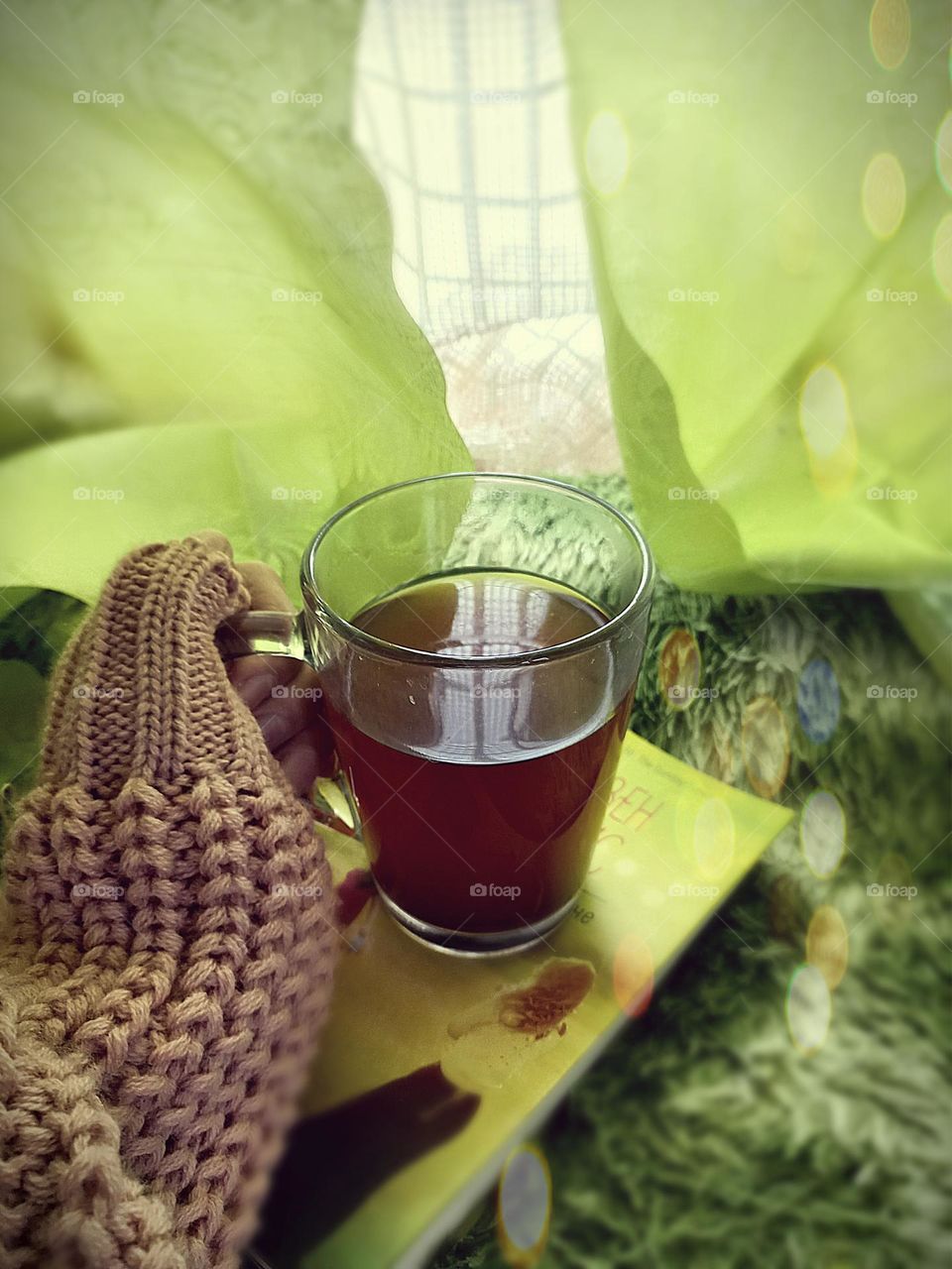 tea and book in winter near windows.