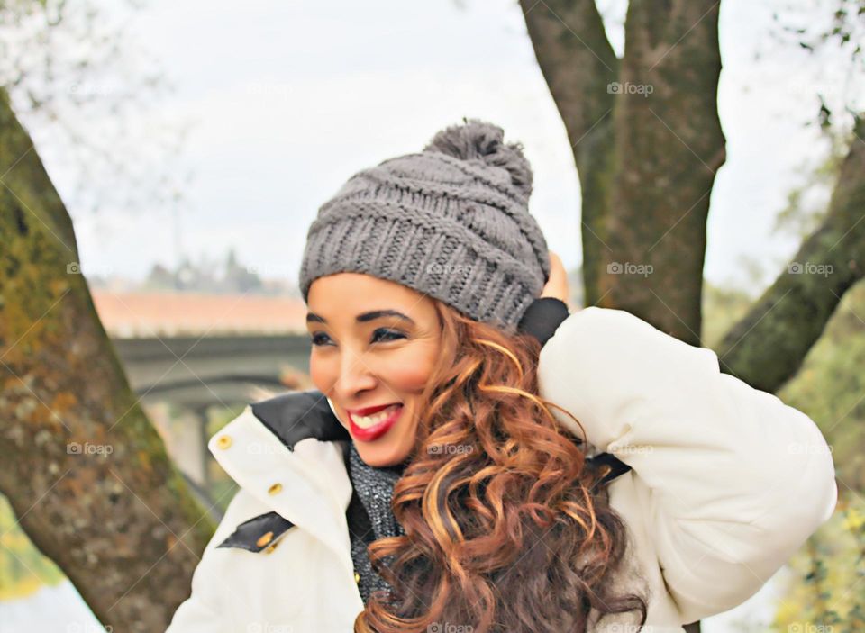 Woman looking away from camera with a hat and a smile