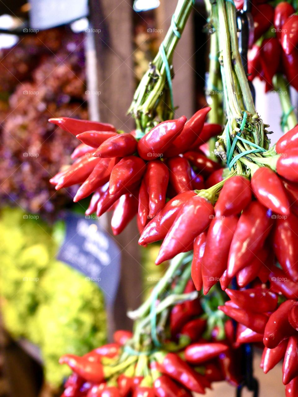 Chilies hanging in bouquets on a wall outdoors