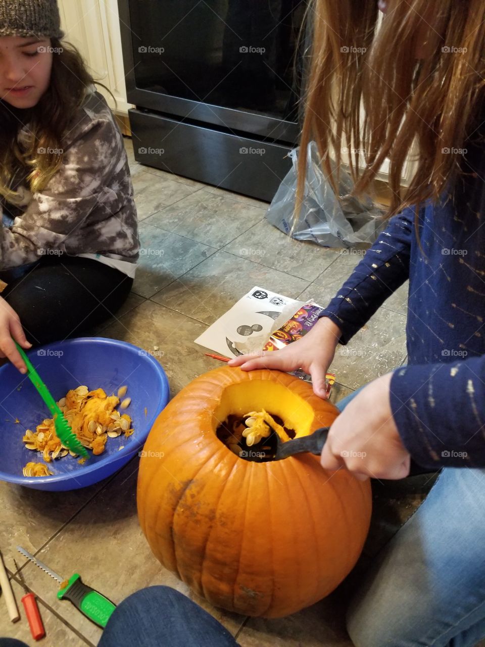 girl scooping out pumpkin seeds