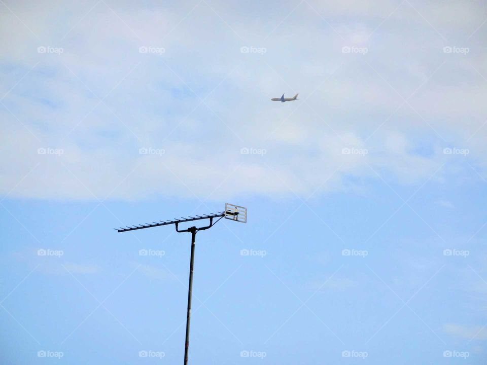 plane in the clouds over the sallite antena