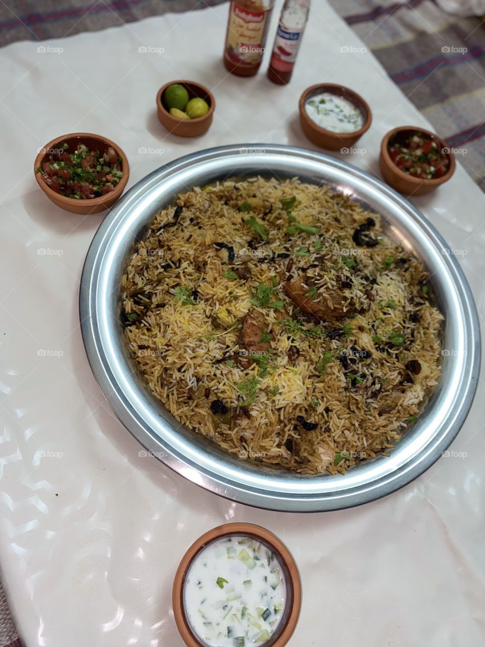 Upside-down kabsa with nuts, tomato and cucumber salad, yogurt and cucumber salad