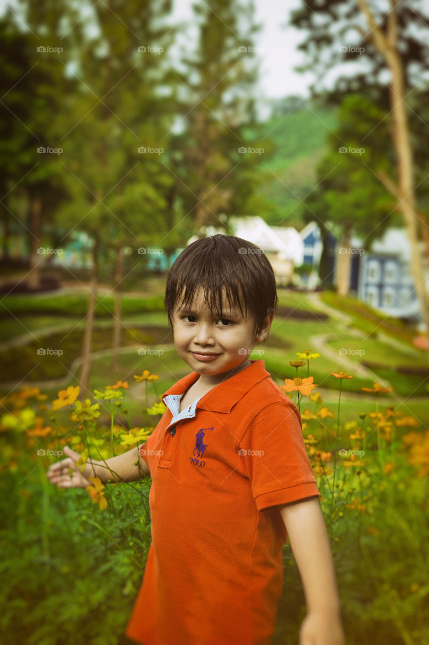 Young kid enjoying spring among the flower. Thitiwin out on a sunny day