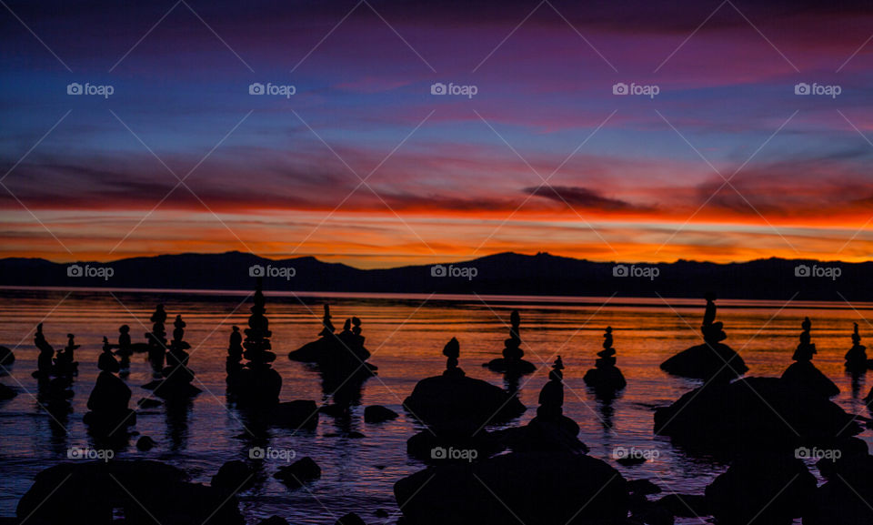 Stunning Lake Tahoe sunset with stacked rocks in foreground 