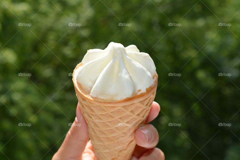 Person's hand holding ice cream cone