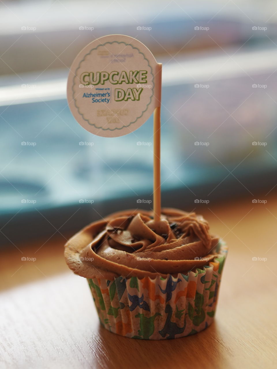 National Cupcake Day for the Alzheimer's Society. A close up charity fundraising cupcake with bokeh background.