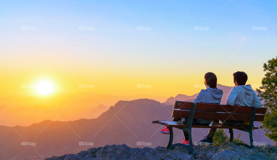 Couple watching the sunset over the mountains.