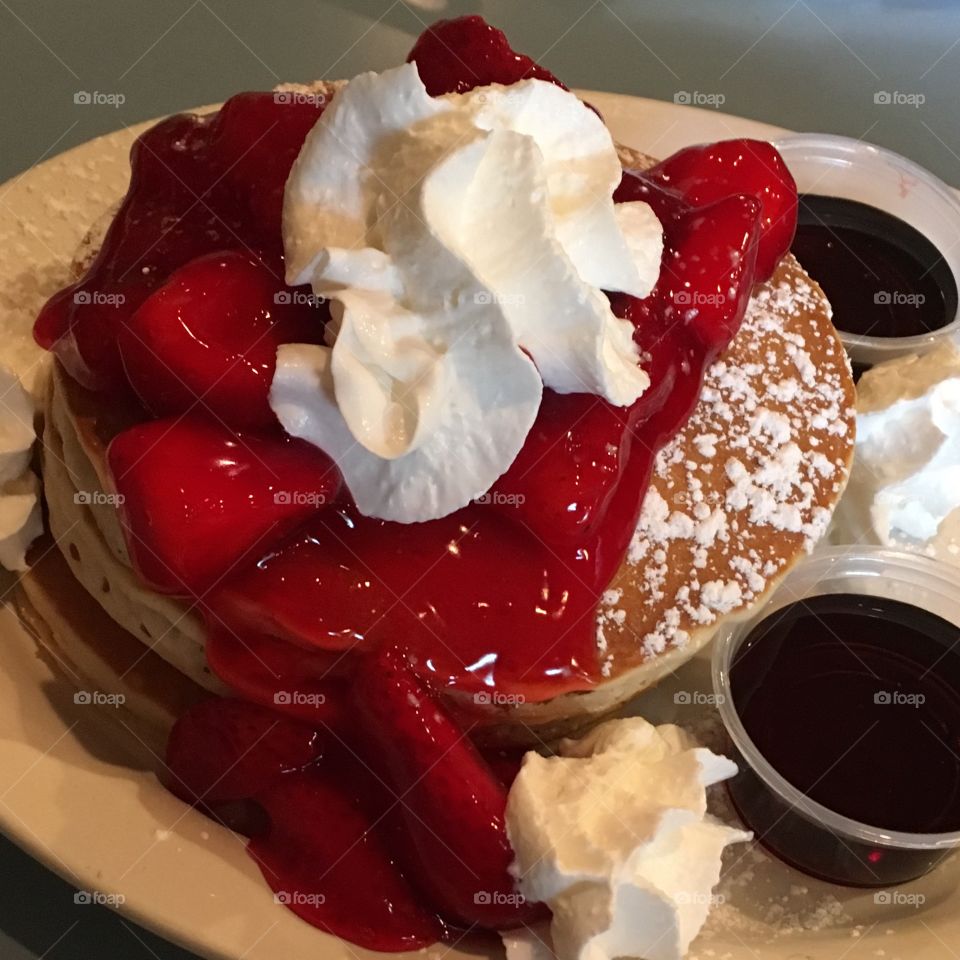 Pancakes with strawberry topping and whipped cream