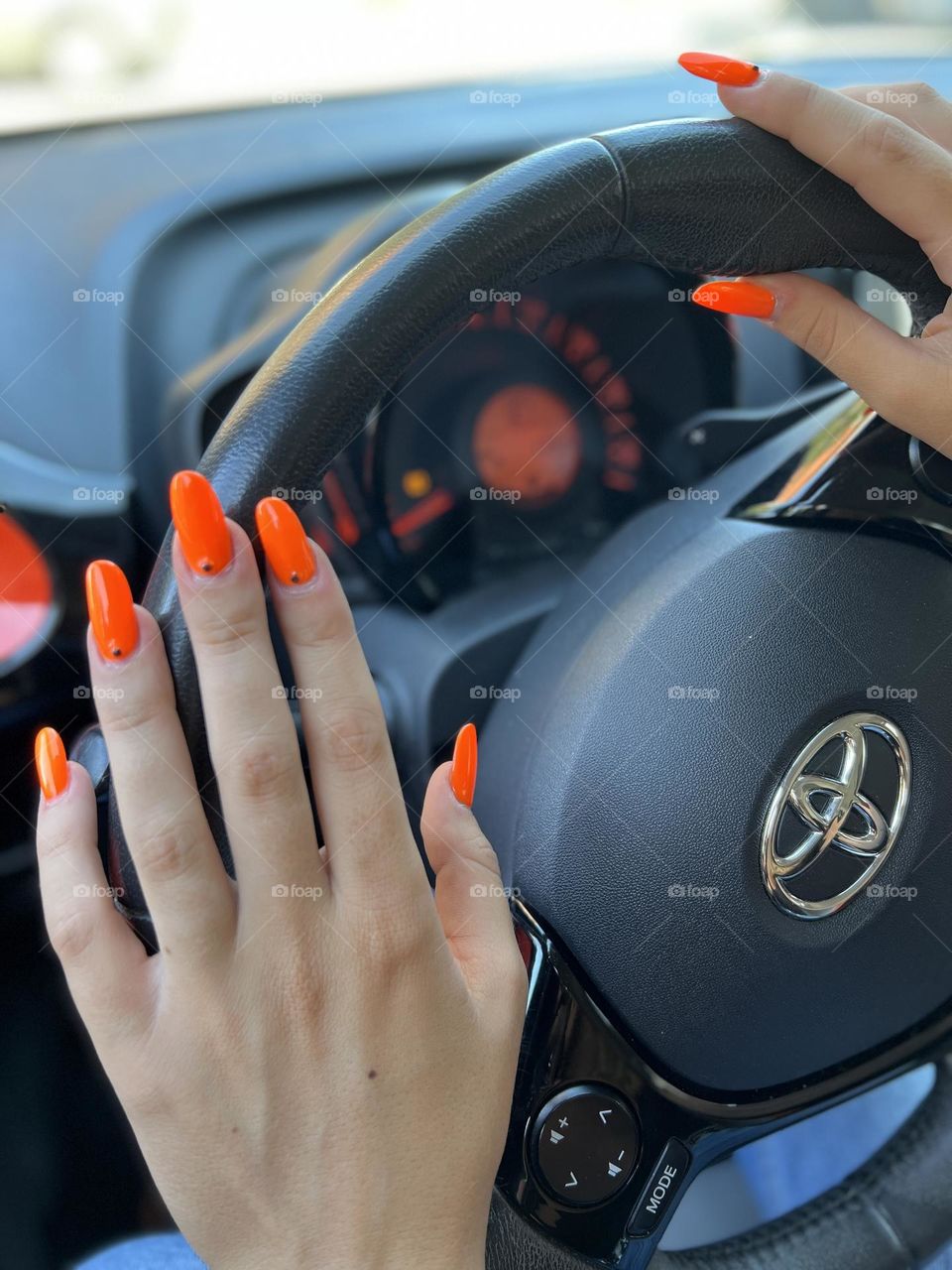 Orange nails on steering wheels