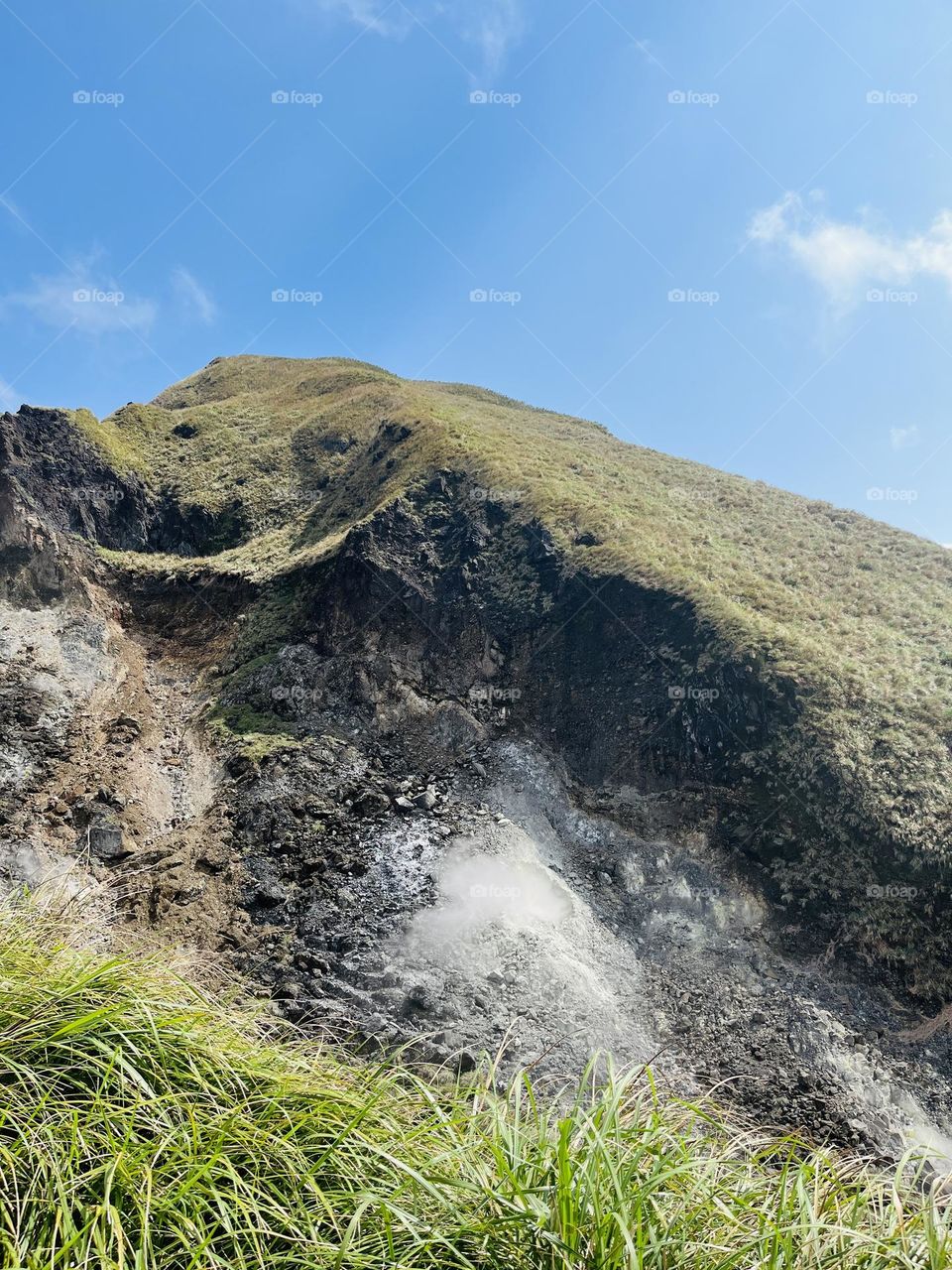 The photo shows smoke rising from sulfur coming out of the mountain, against the backdrop of a beautiful blue sky. This photo captures the magic and wonder of nature. Want to experience the natural beauty firsthand? Come visit Yangmingshan!