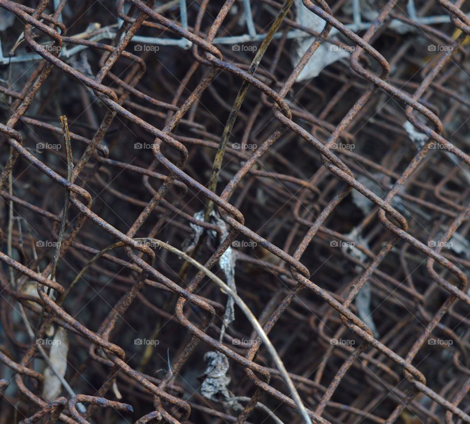 grid Chain-link in a roll background on the desktop wallpaper boring depressing metal monotony and intricacy in the depths of the rusty weaves of an old wire product.