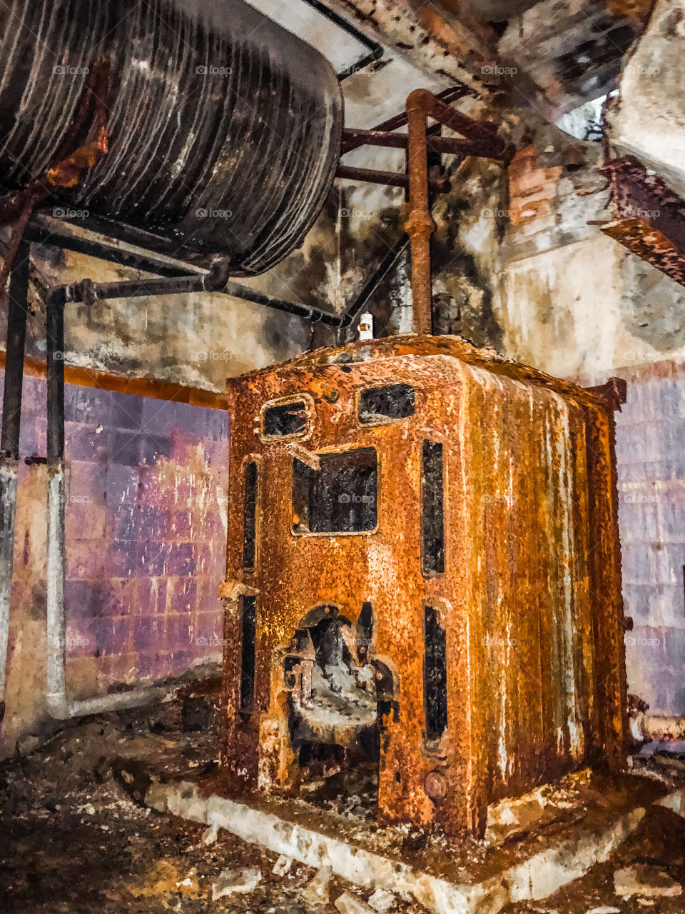 Rusty, derelict furnace and old water tank surrounded by faded purple tiled room in abandoned hotel - Portugal